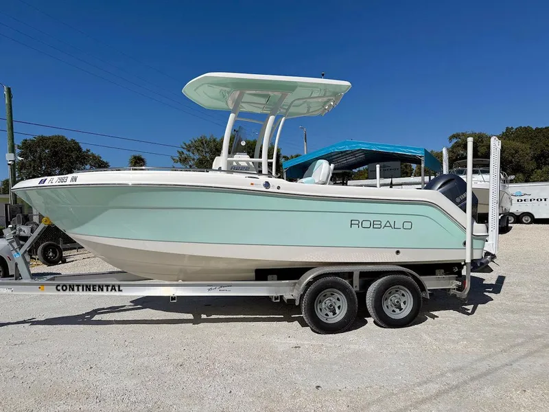 Slide: The Image of 2018 Robalo R222 Center Console boat on trailer, parked outdoors under clear blue sky. - 4