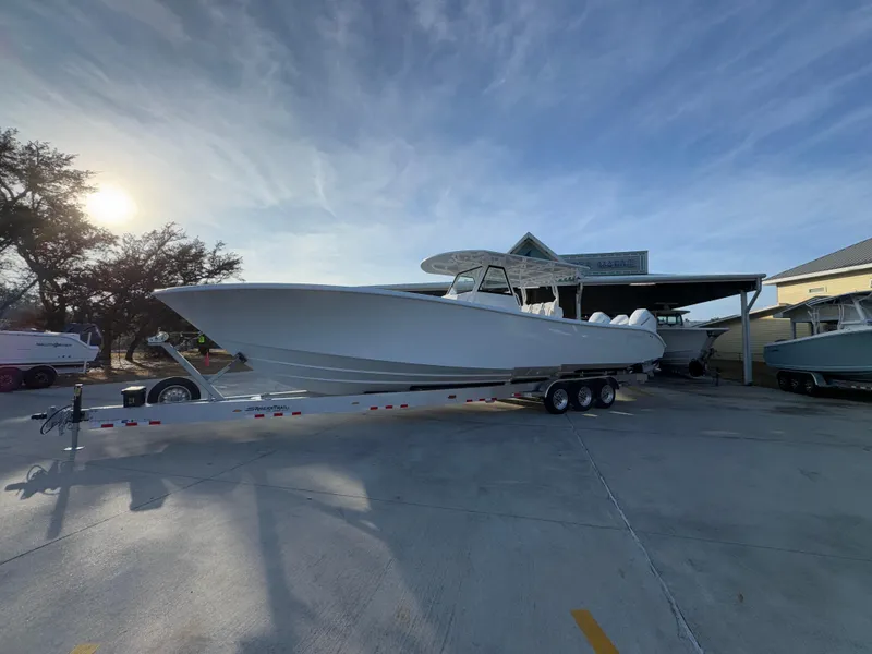Slide: The Image of 2025 Yellowfin 39 Offshore boat on trailer, parked outdoors under a clear sky. - 16