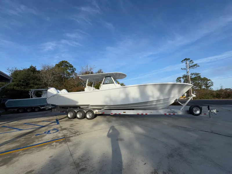 Slide: The Image of 2025 Yellowfin 39 Offshore boat on a trailer, parked outdoors under a clear sky. - 25