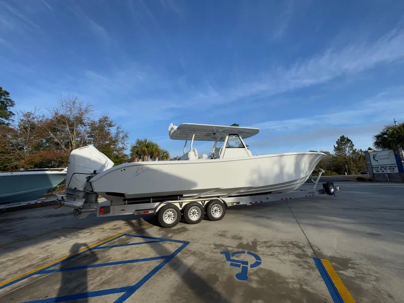 Slide: The Image of 2025 Yellowfin 39 Offshore boat on trailer in parking lot under clear sky. - 27