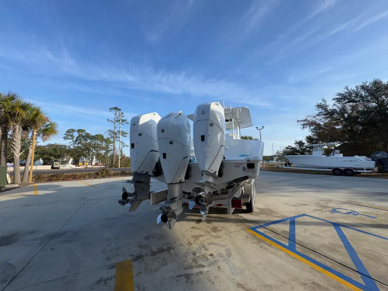 Slide: The Image of 2025 Yellowfin 39 Offshore boat with triple outboard engines in a parking area. - 32