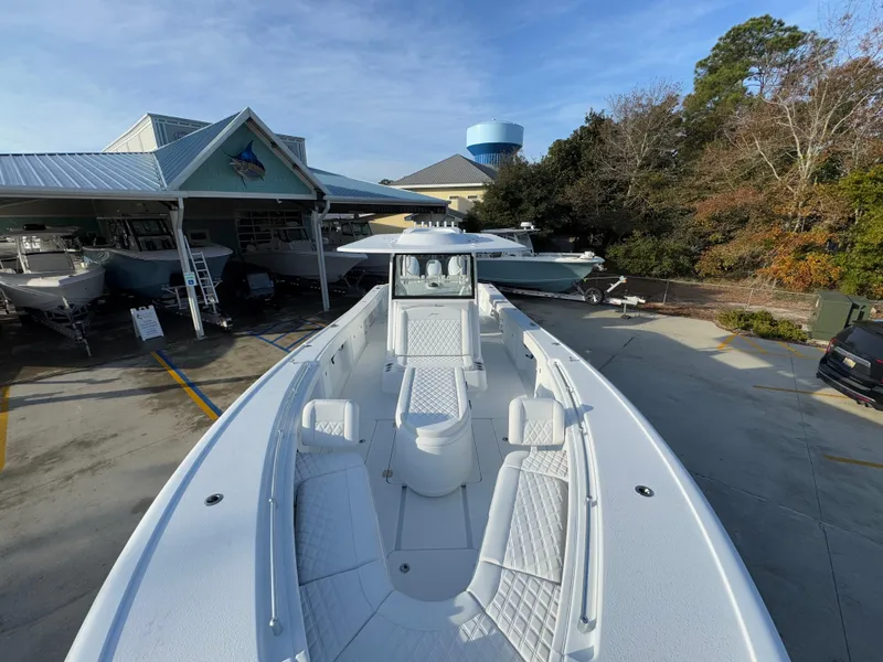 Slide: The Image of 2025 Yellowfin 39 Offshore boat displayed at a dealership, showcasing spacious deck and seating. - 38