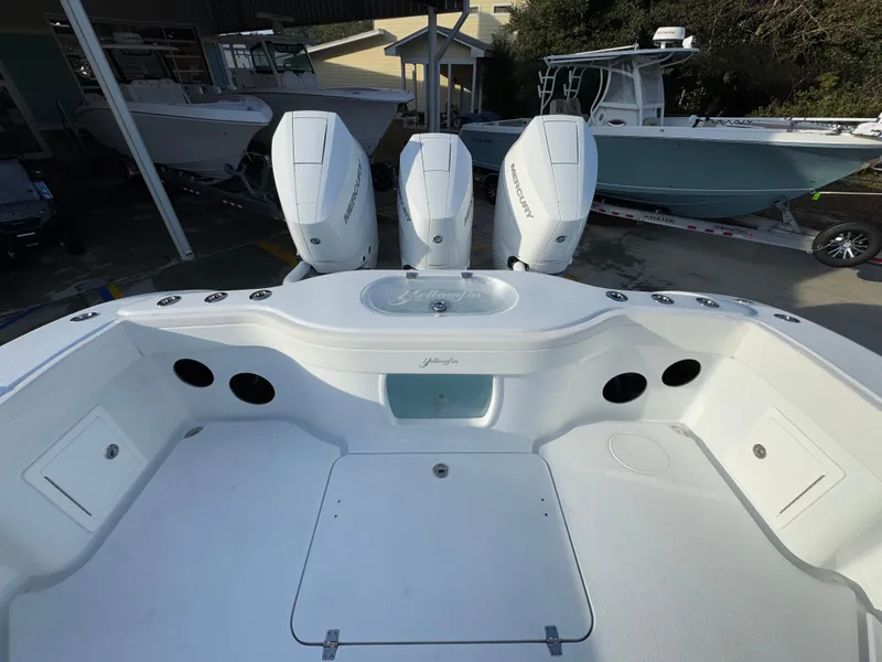 Slide: The Image of 2025 Yellowfin 39 Offshore boat with triple outboard engines, docked at a marina. - 57