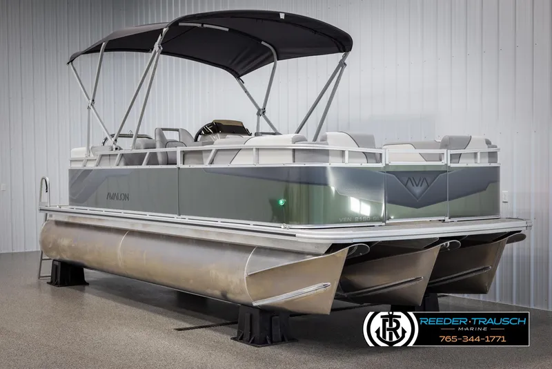 Slide: The Image of 2025 Avalon VEN QL pontoon boat with canopy in showroom, featuring sleek design and modern amenities. - 3