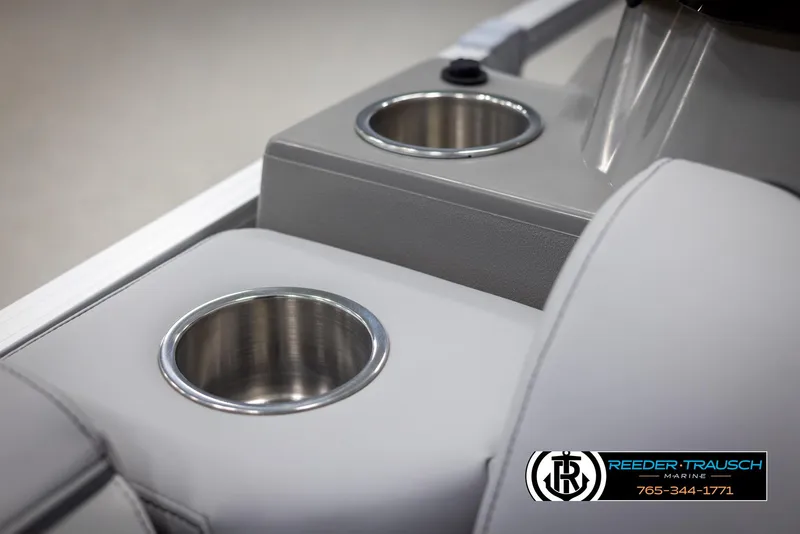 Slide: The Image of Avalon VEN QL 2025 boat interior with dual cup holders, Reeder-Trausch Marine logo. - 35