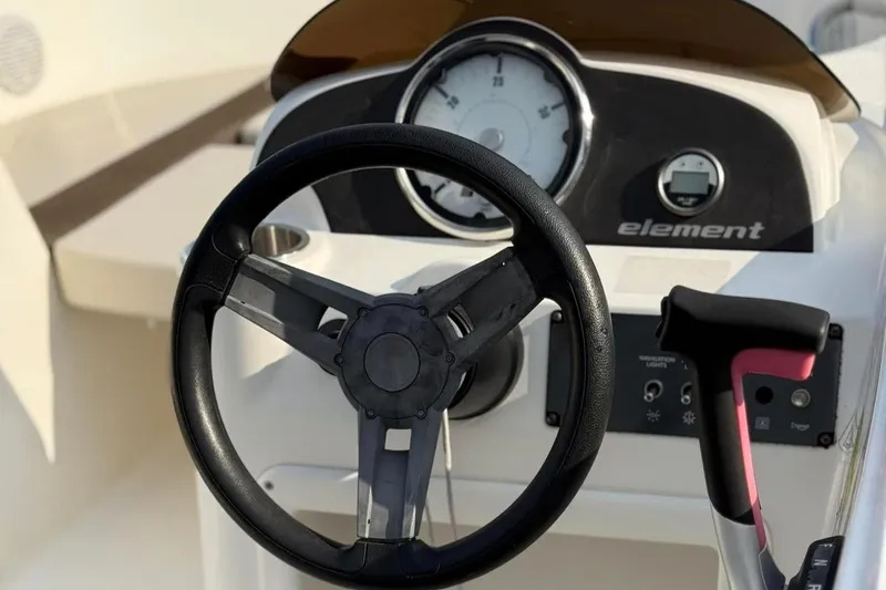 Slide: The Image of Steering wheel and dashboard of 2021 Bayliner Element 160EL boat. - 2