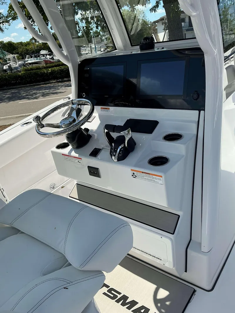 Slide: The Image of 2025 Sportsman 262 Open boat dashboard with steering wheel and dual screens. - 16