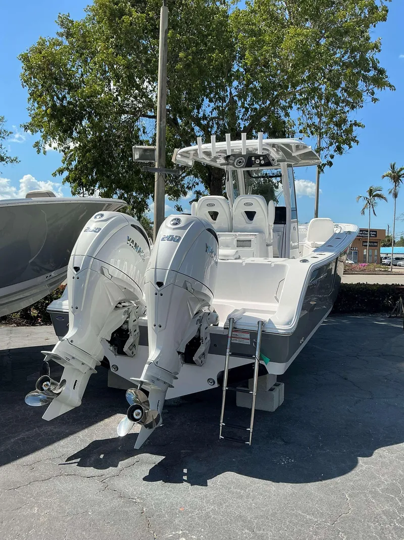 Slide: The Image of 2025 Sportsman 262 Open boat with dual Yamaha engines, parked outdoors. - 3