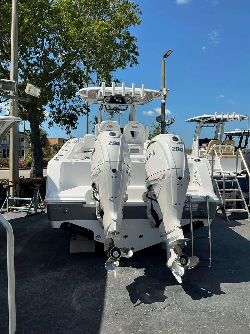 Slide: The Image of 2025 Sportsman 262 Open boat with dual Yamaha 200 engines, parked outdoors. - 4