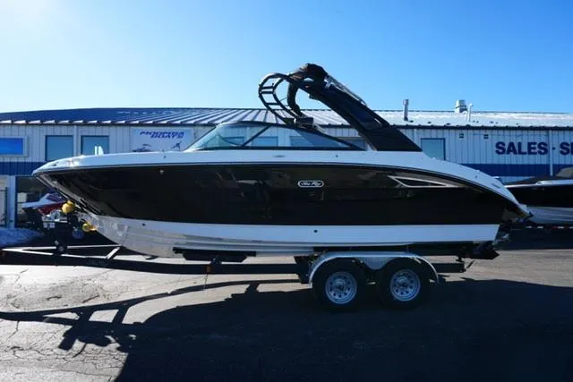 The Image of 2025 Sea Ray SDX 250 boat on trailer, parked outside a sales showroom. - 1
