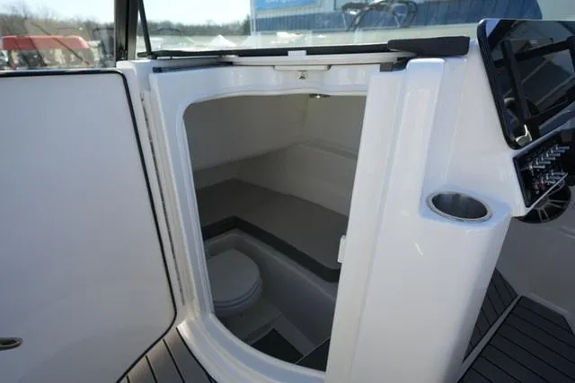 Slide: The Image of 2025 Sea Ray SDX 250 boat interior with compact restroom. - 13