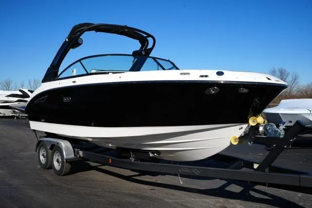 Slide: The Image of 2025 Sea Ray SDX 250 boat on trailer, black and white design, parked outdoors. - 3