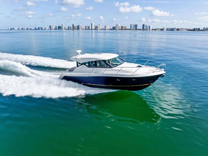 Slide: The Image of 2019 Tiara Yachts 39 Coupe cruising on calm waters with city skyline in background. - 15
