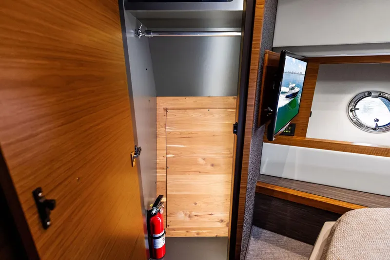 Slide: The Image of 2019 Tiara Yachts 39 Coupe interior with closet, fire extinguisher, and porthole view. - 39