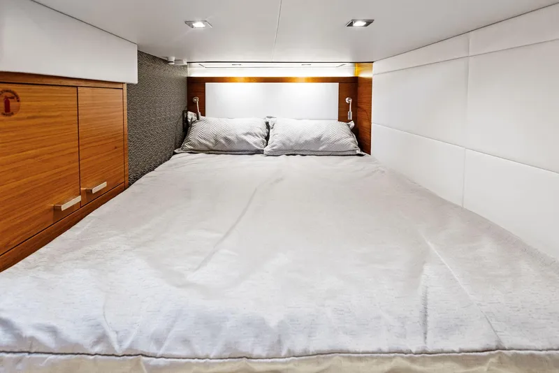 Slide: The Image of 2019 Tiara Yachts 39 Coupe bedroom with cozy bed and modern wood accents. - 40