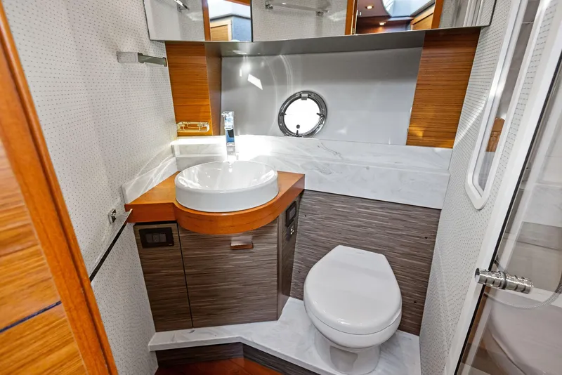 Slide: The Image of Luxurious bathroom in 2019 Tiara Yachts 39 Coupe with modern fixtures and porthole window. - 43