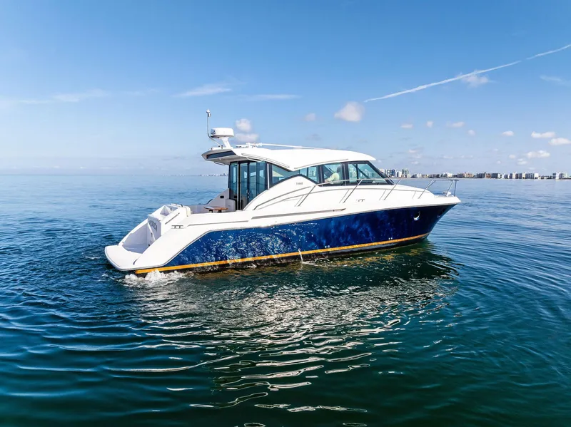 Slide: The Image of 2019 Tiara Yachts 39 Coupe on calm water under clear blue sky. - 6