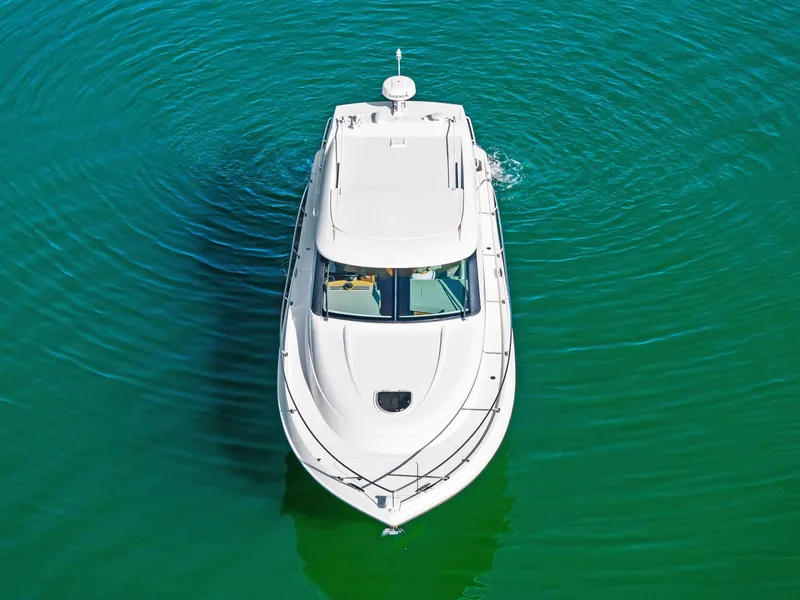 Slide: The Image of 2019 Tiara Yachts 39 Coupe cruising on clear green water. - 7
