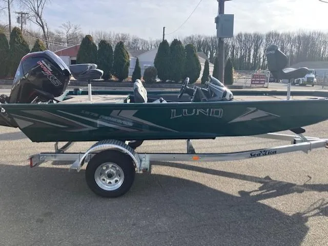Slide: The Image of 2025 Lund 1875 Renegade SS boat on trailer, parked outdoors. - 2