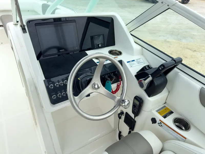 Slide: The Image of 2022 World Cat 230 SD boat dashboard with steering wheel and control panel. - 11