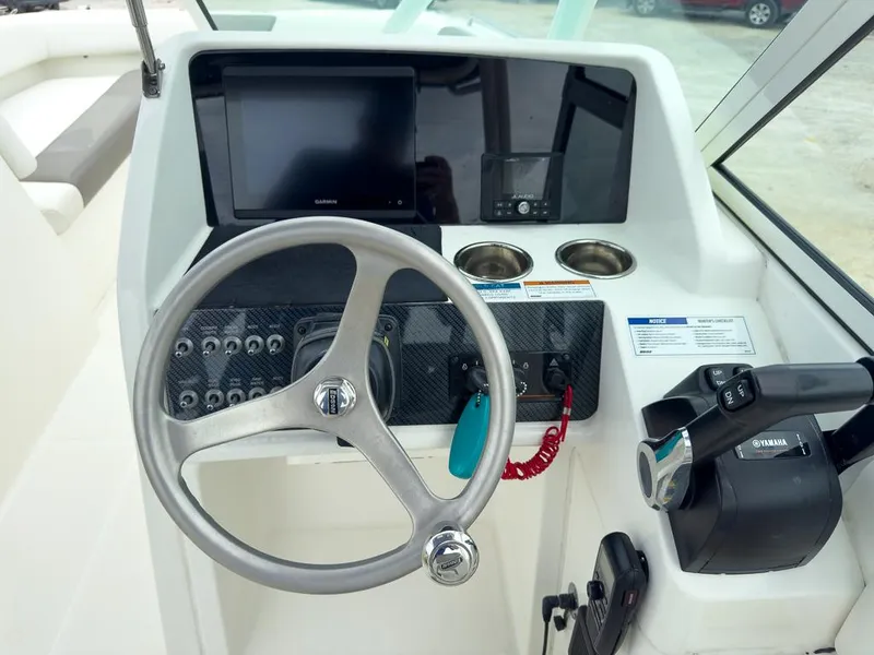 Slide: The Image of 2022 World Cat 230 SD boat dashboard with steering wheel and control panel. - 12