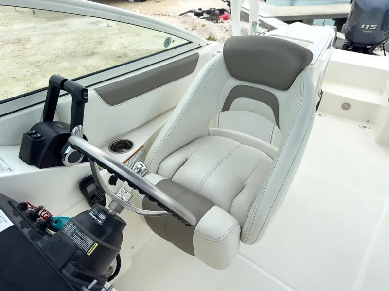 Slide: The Image of Captain's seat of 2022 World Cat 230 SD boat, featuring modern design and controls. - 13