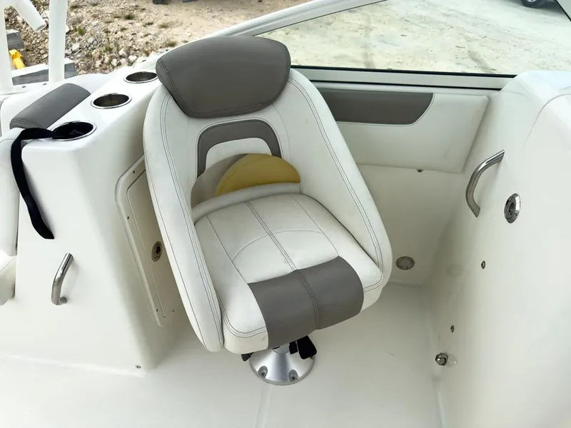 Slide: The Image of 2022 World Cat 230 SD boat seat with white and gray upholstery, cup holders, and armrest. - 14