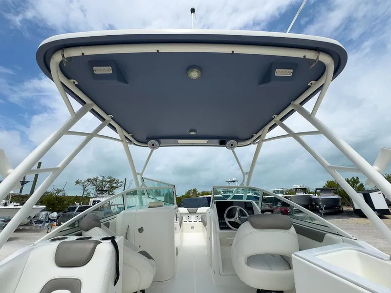 Slide: The Image of 2022 World Cat 230 SD boat interior with seating and canopy under a cloudy sky. - 16