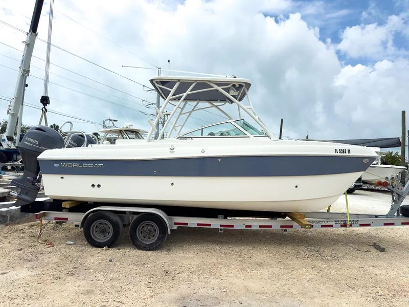 Slide: The Image of 2022 World Cat 230 SD boat on trailer, parked outdoors under cloudy sky. - 3