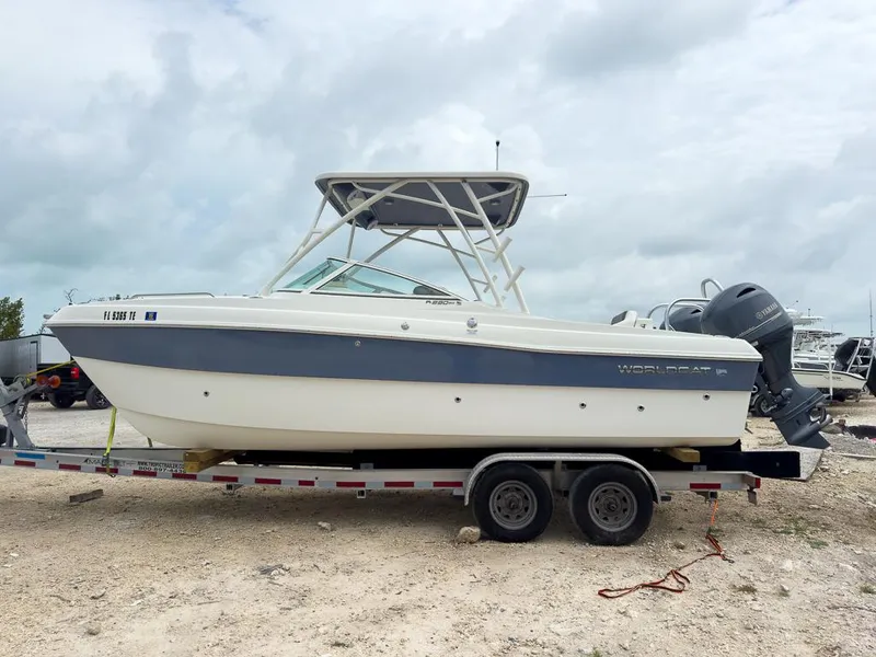 Slide: The Image of 2022 World Cat 230 SD boat on trailer, parked outdoors under cloudy sky. - 6