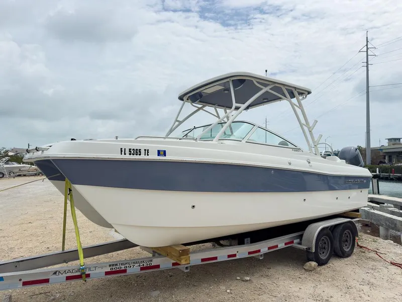 Slide: The Image of 2022 World Cat 230 SD boat on trailer, parked near waterfront. - 7