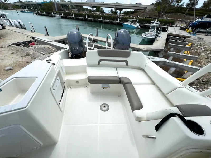 Slide: The Image of 2022 World Cat 230 SD boat interior with seating, docked by a marina. - 9