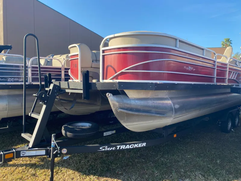 The Image of 2020 Sun Tracker Party Barge 24 DLX pontoon boat on trailer, red and white design. - 0