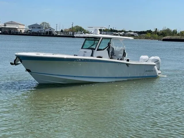 Slide: The Image of 2022 Blackfin 332 CC boat on calm water, featuring sleek design and twin engines. - 10