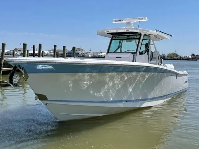 Slide: The Image of 2022 Blackfin 332 CC boat docked in calm waters under a clear blue sky. - 11