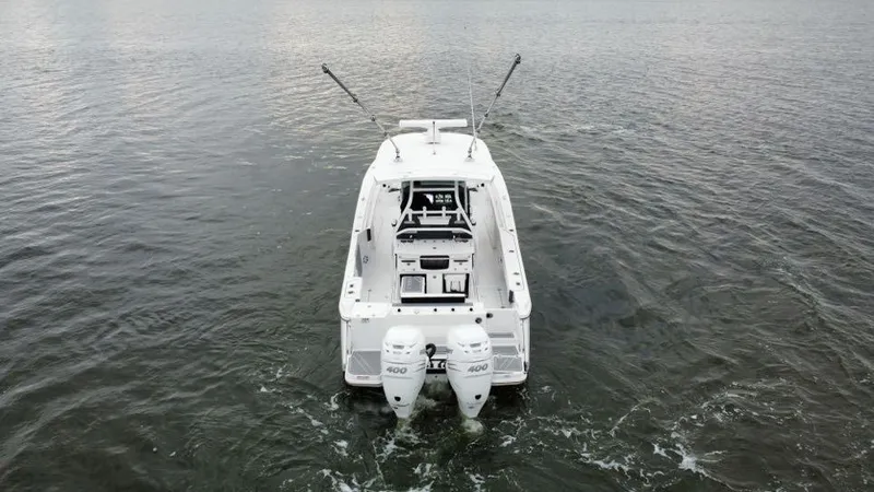 Slide: The Image of 2022 Blackfin 332 CC boat on water, rear view with dual engines. - 2