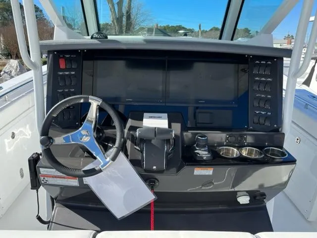 Slide: The Image of 2022 Blackfin 332 CC boat dashboard with steering wheel and control panel. - 20
