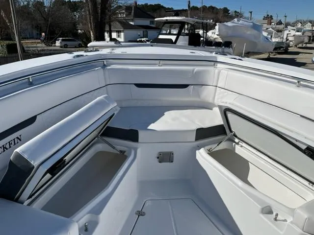 Slide: The Image of 2022 Blackfin 332 CC boat interior with open storage compartments, docked outdoors. - 25