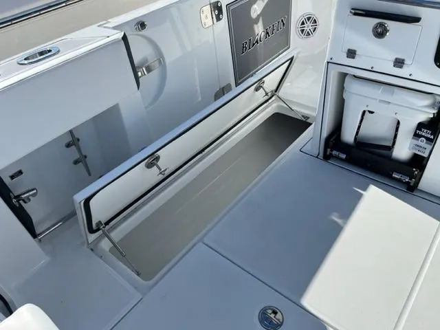 Slide: The Image of 2022 Blackfin 332 CC boat interior with storage compartments and cooler. - 32