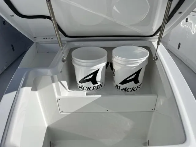 Slide: The Image of 2022 Blackfin 332 CC boat storage compartment with two branded buckets. - 34