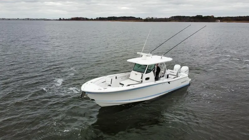 Slide: The Image of 2022 Blackfin 332 CC boat cruising on open water under cloudy skies. - 4