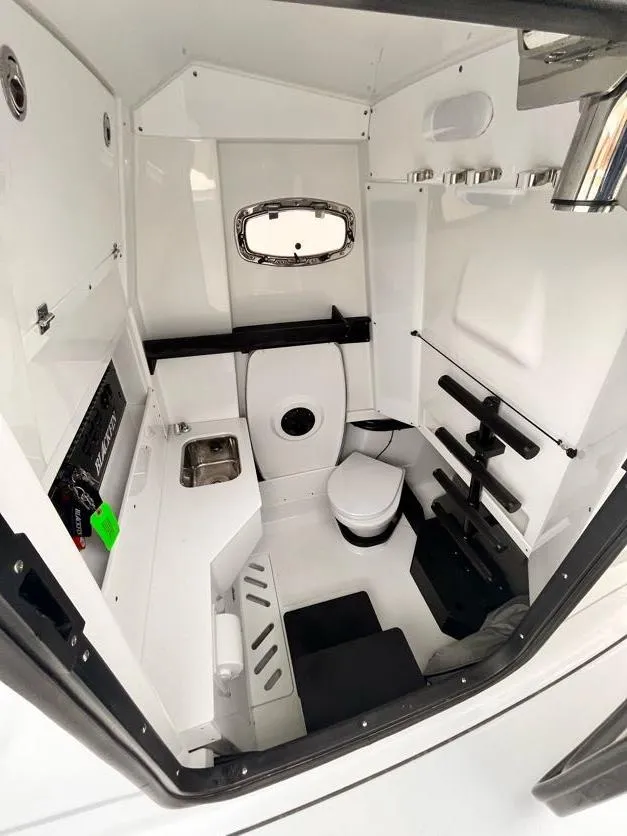 Slide: The Image of Interior of 2022 Blackfin 332 CC boat, featuring compact bathroom with sink and toilet. - 8