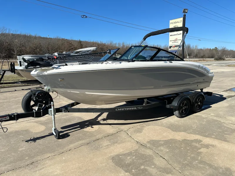 Slide: The Image of 2025 Chaparral 21 SSi Ski & Fish boat on trailer, parked outdoors. - 2