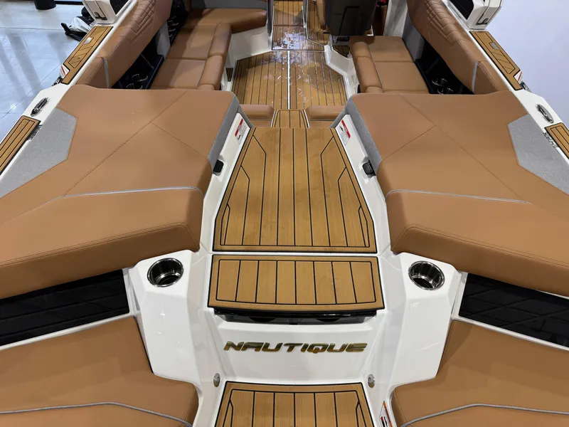 Slide: The Image of 2025 Nautique Super Air Nautique S23 interior with tan seating and wood accents. - 10