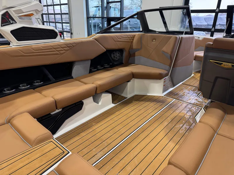Slide: The Image of 2025 Nautique Super Air Nautique S23 interior with tan leather seating and teak flooring. - 14