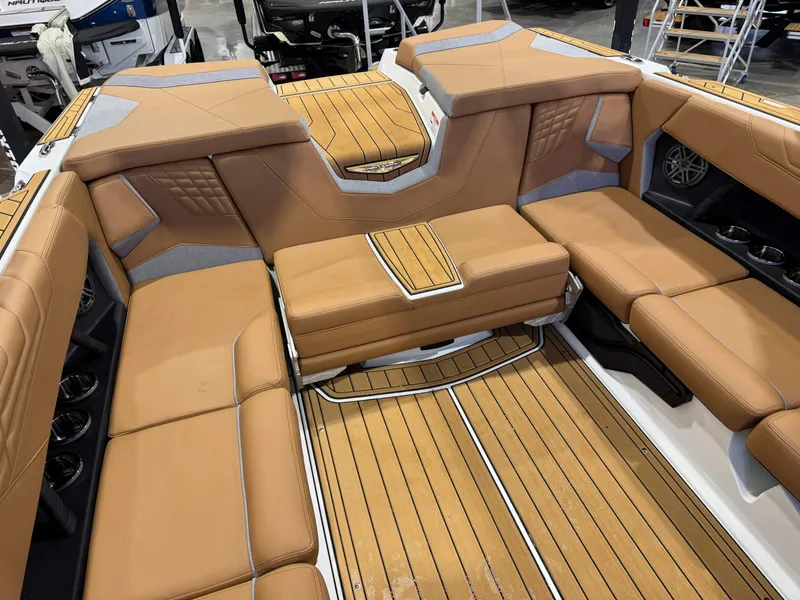 Slide: The Image of 2025 Nautique Super Air Nautique S23 interior with tan leather seating and wood flooring. - 16