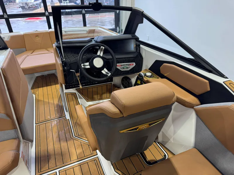 Slide: The Image of 2025 Nautique Super Air Nautique S23 interior with tan seating and modern dashboard. - 24