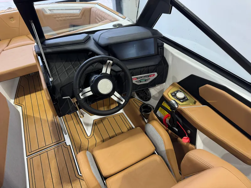 Slide: The Image of 2025 Nautique Super Air Nautique S23 interior with tan seating and modern dashboard. - 25