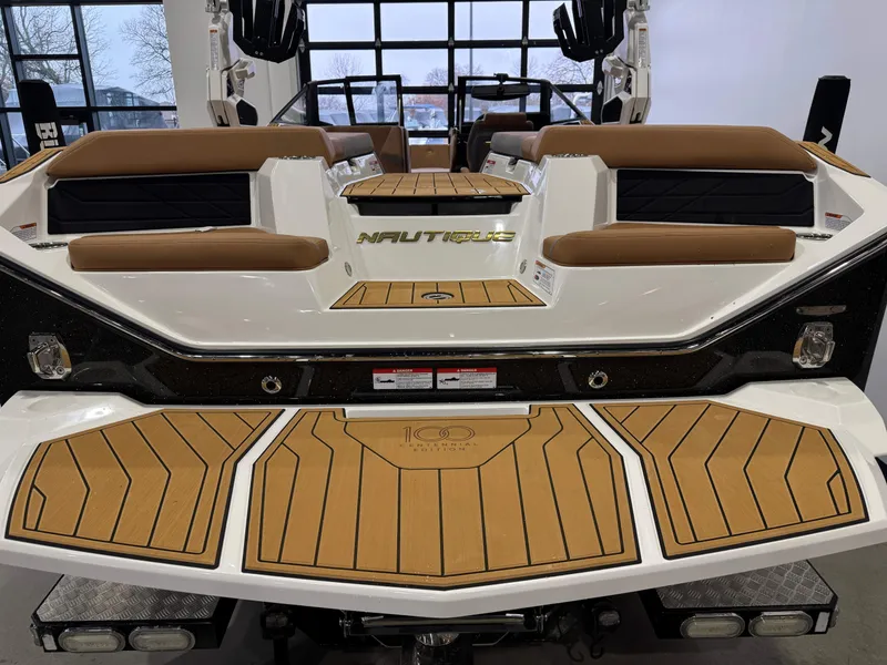 Slide: The Image of 2025 Nautique Super Air Nautique S23 boat interior with brown seating and teak flooring. - 8