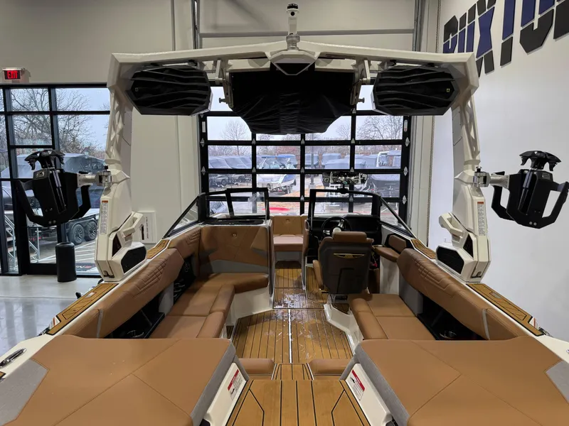 Slide: The Image of 2025 Nautique Super Air Nautique S23 interior with tan seating and advanced audio system. - 9